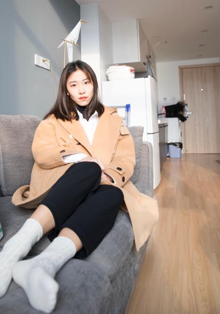 沙发上的杏色外套少女